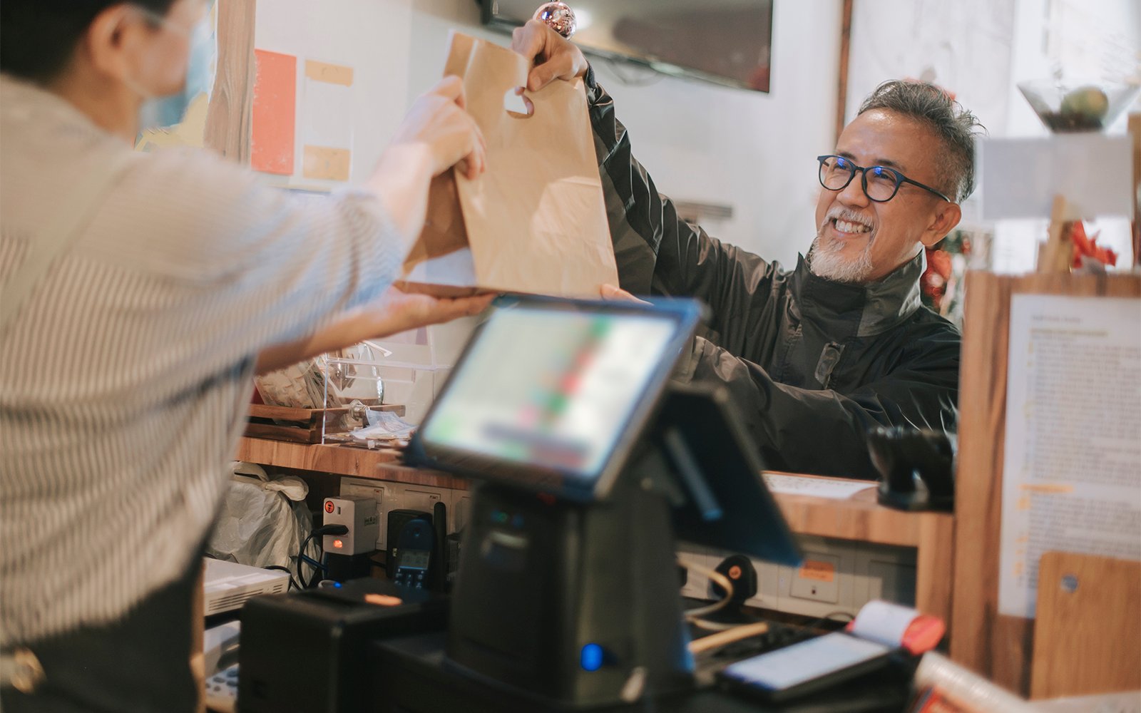 side hustle asian chinese senior man delivery picking up take away food from cashier